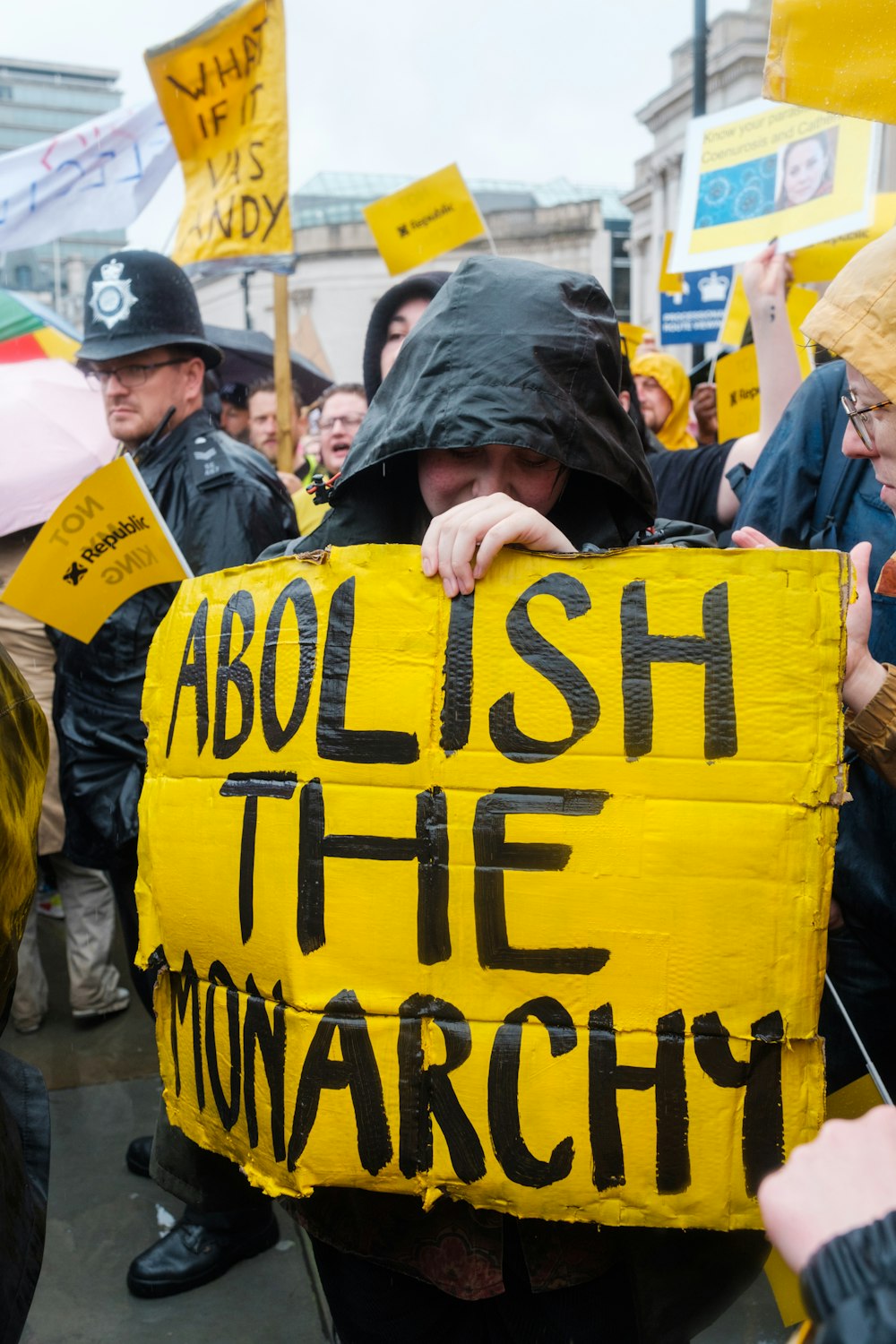 a group of people holding up signs and umbrellas