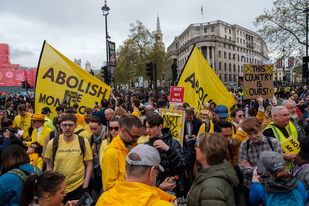 a large group of people holding yellow signs