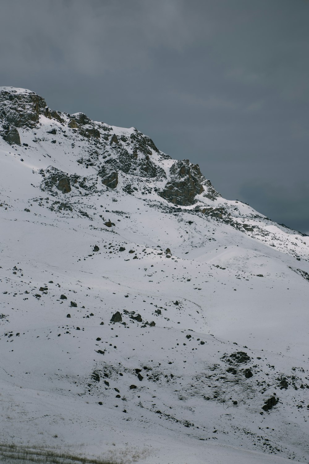 a snow covered mountain with a cloudy sky