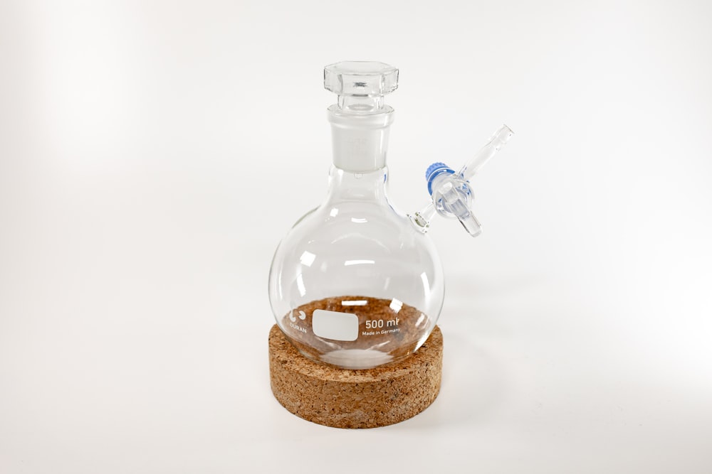 una bottiglia di vetro con un tappo di sughero su sfondo bianco
