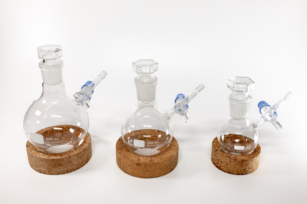 three glass bottles with a cork base and a cork stopper