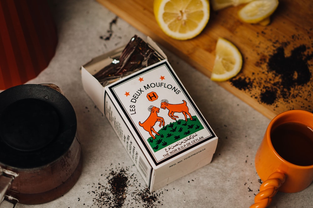 a box of ground coffee next to a cup of coffee