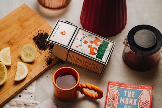 a cup of tea next to a box of lemons