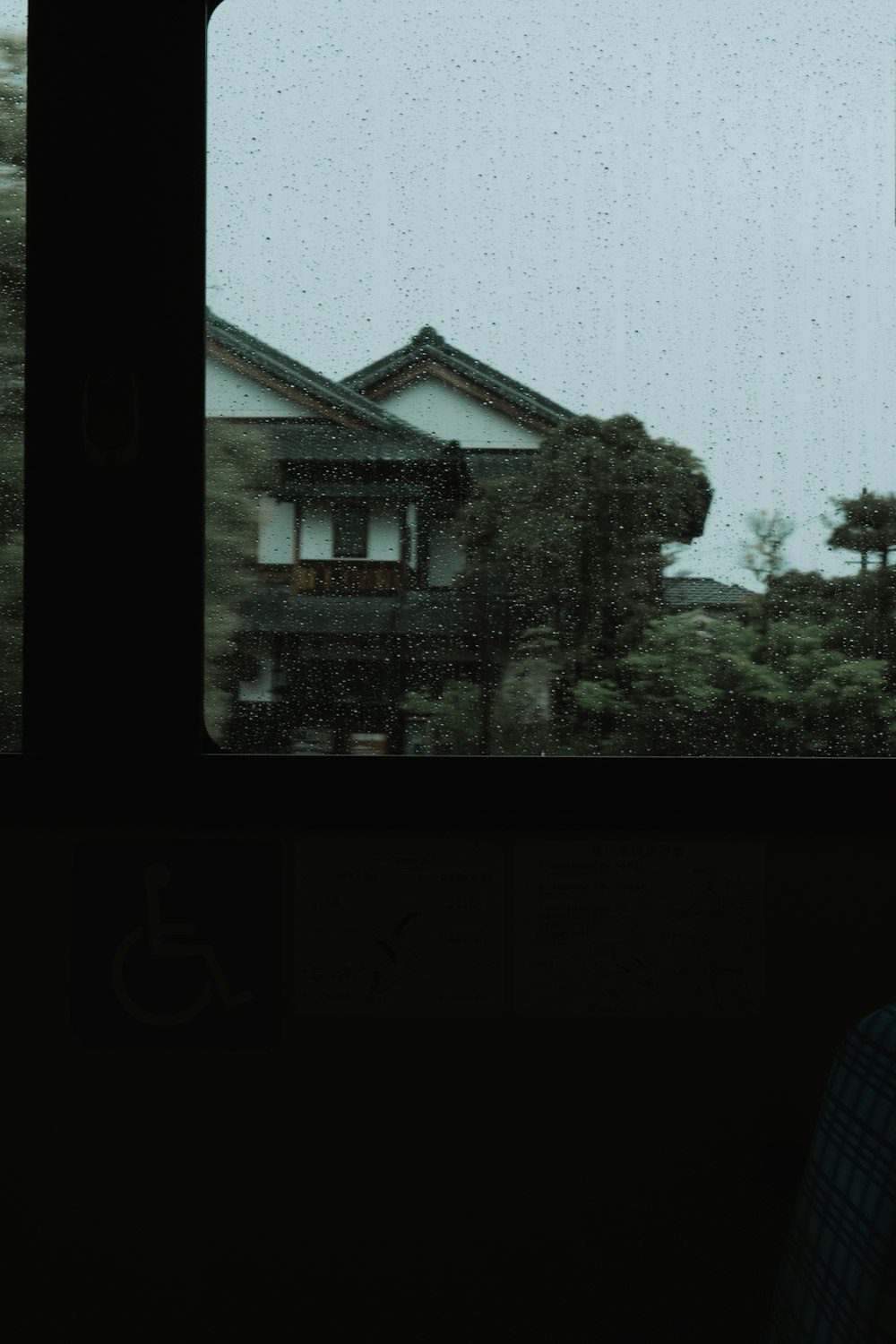 a person looking out of a window at a house