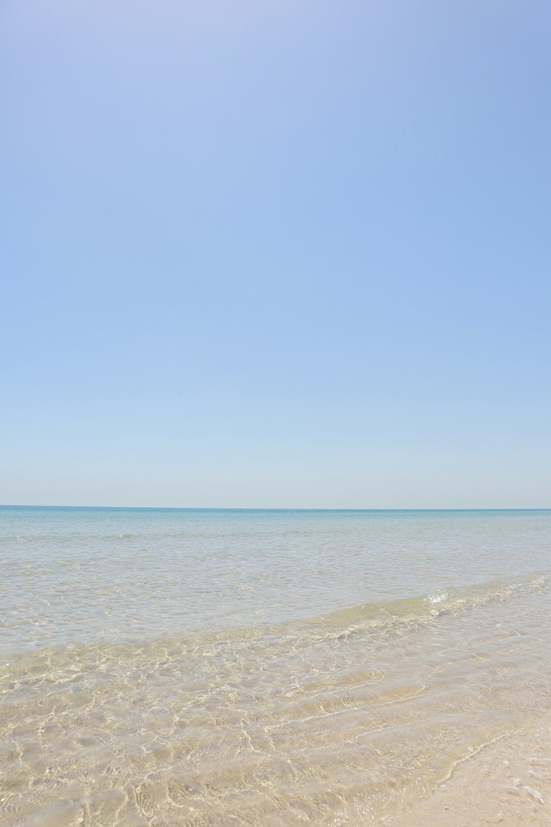 a person walking on the beach with a surfboard