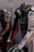 Two motorcycle racing suits are displayed side by side, adorned with various sponsor logos and designs. The suit in the foreground features logos such as Xerox, AMD, and Shell, and has a color scheme of red, blue, and white with intricate graphics. A helmet with a striking design can be seen at the bottom of the display.