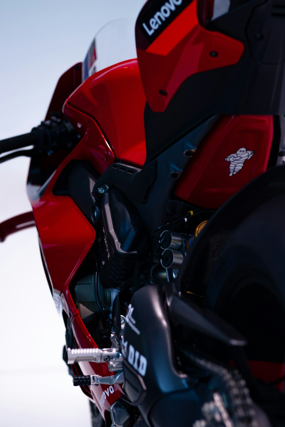 a red and black motorcycle parked in a parking lot