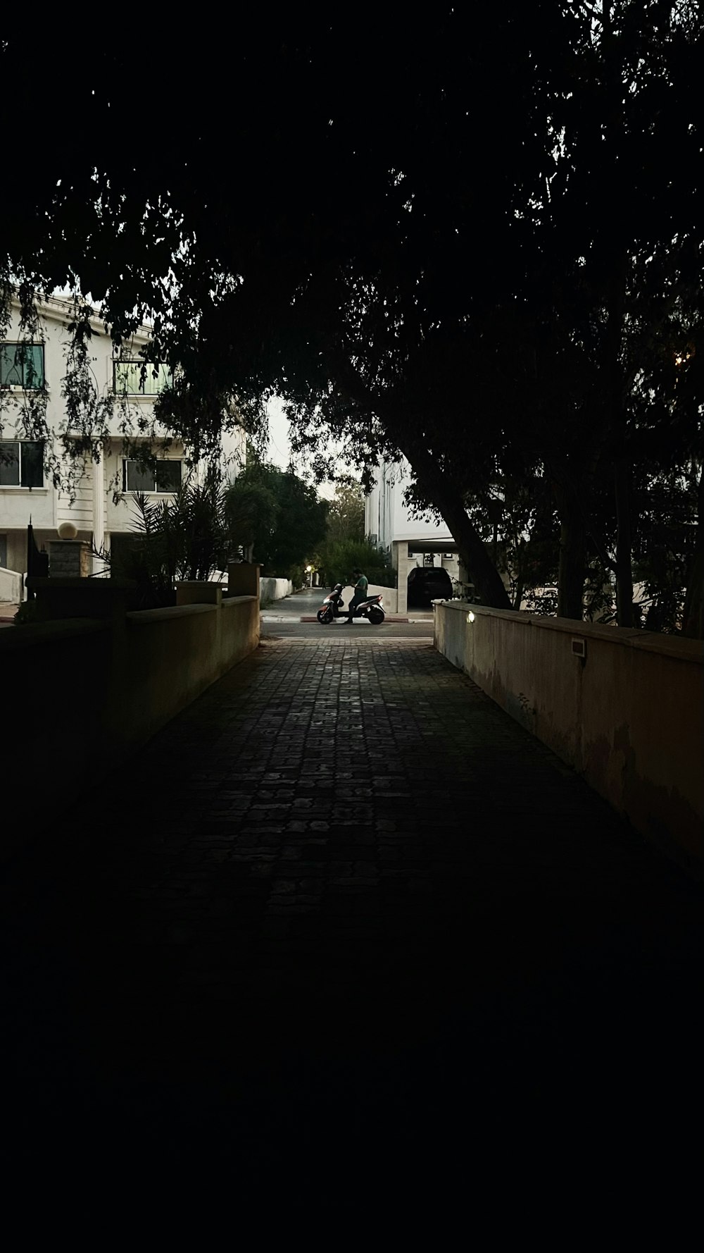 a dark street with cars parked on the side of it