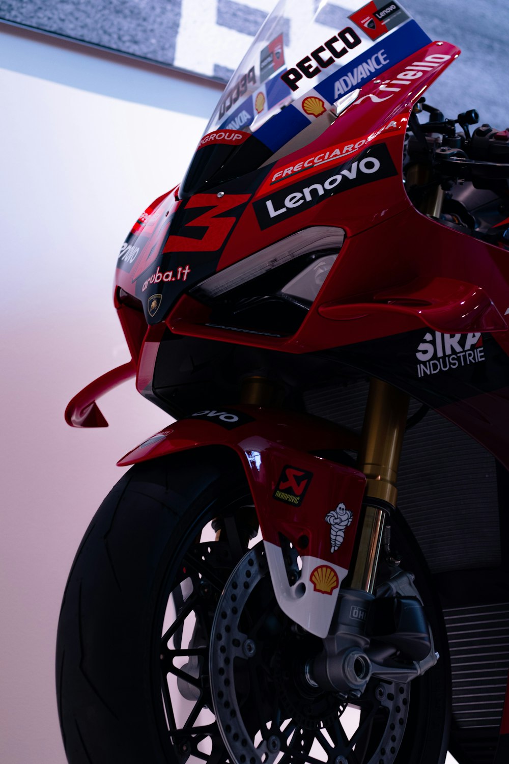 a red motorcycle parked on top of a white floor