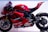 A sleek, red racing motorcycle featuring several sponsor logos such as Lenovo and NetApp. The bike has a streamlined design with a prominent windshield and visible mechanical components. Its rear swingarm and large rear tire indicate its high-performance capabilities.