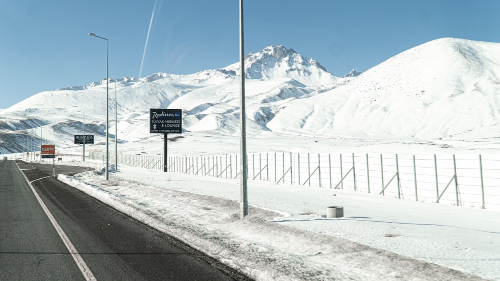 a snowy road with a mountain in the background