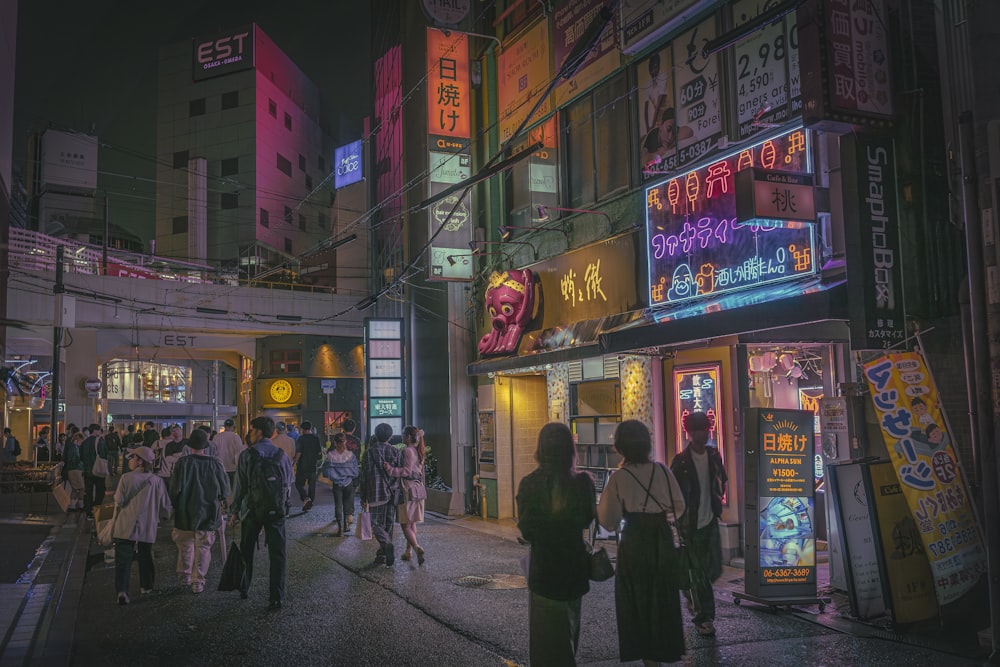 a group of people walking down a street next to tall buildings