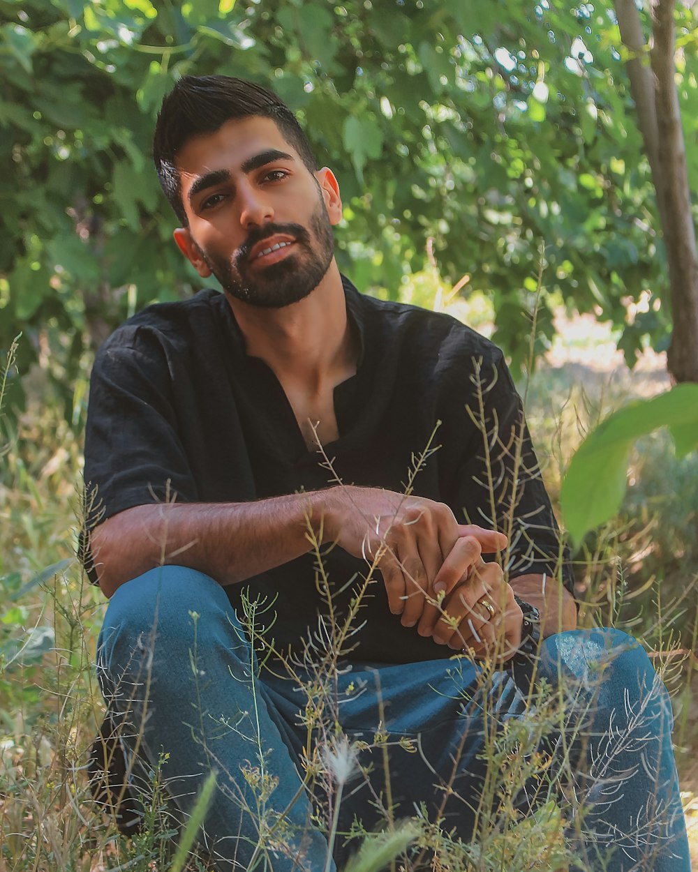 a man sitting in a field of tall grass