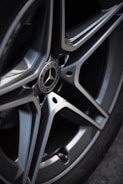 Close-up of a car’s shiny rims rotating against a clean background.
