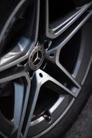 View of the car's sporty alloy wheels gleaming on a clean concrete surface.