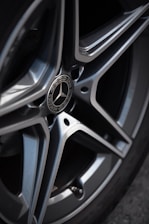 Close-up of a car’s shiny rims rotating against a clean background.