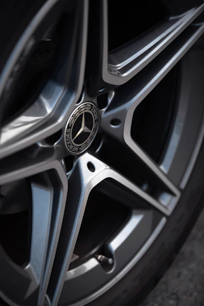 Close-up of a polished silver sports car wheel reflecting ambient light.