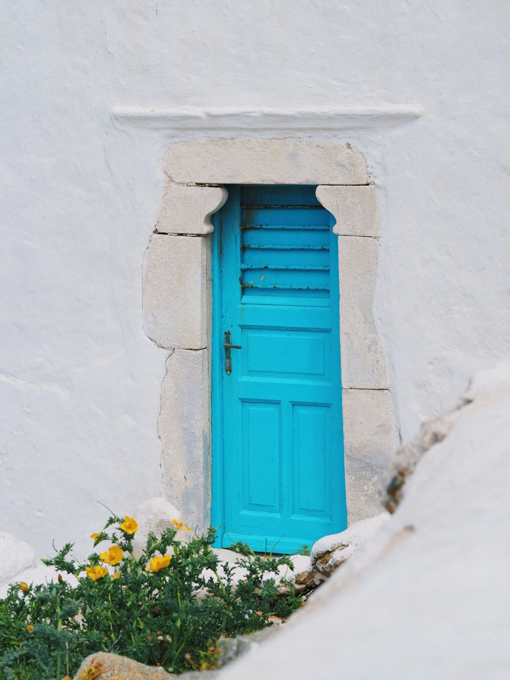 Une porte bleue est ouverte dans un bâtiment blanc
