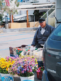 un homme assis sur un banc à côté d'un bouquet de fleurs