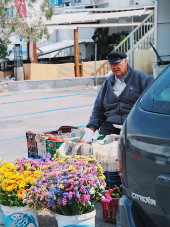 un homme assis sur un banc à côté d'un bouquet de fleurs