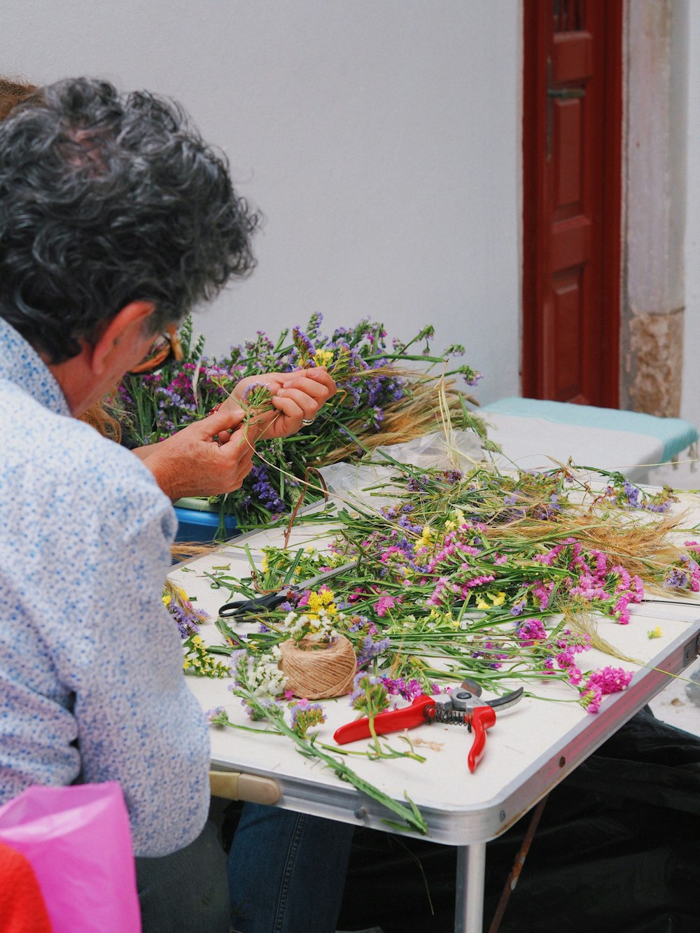 uma mulher sentada em uma mesa com um ramo de flores