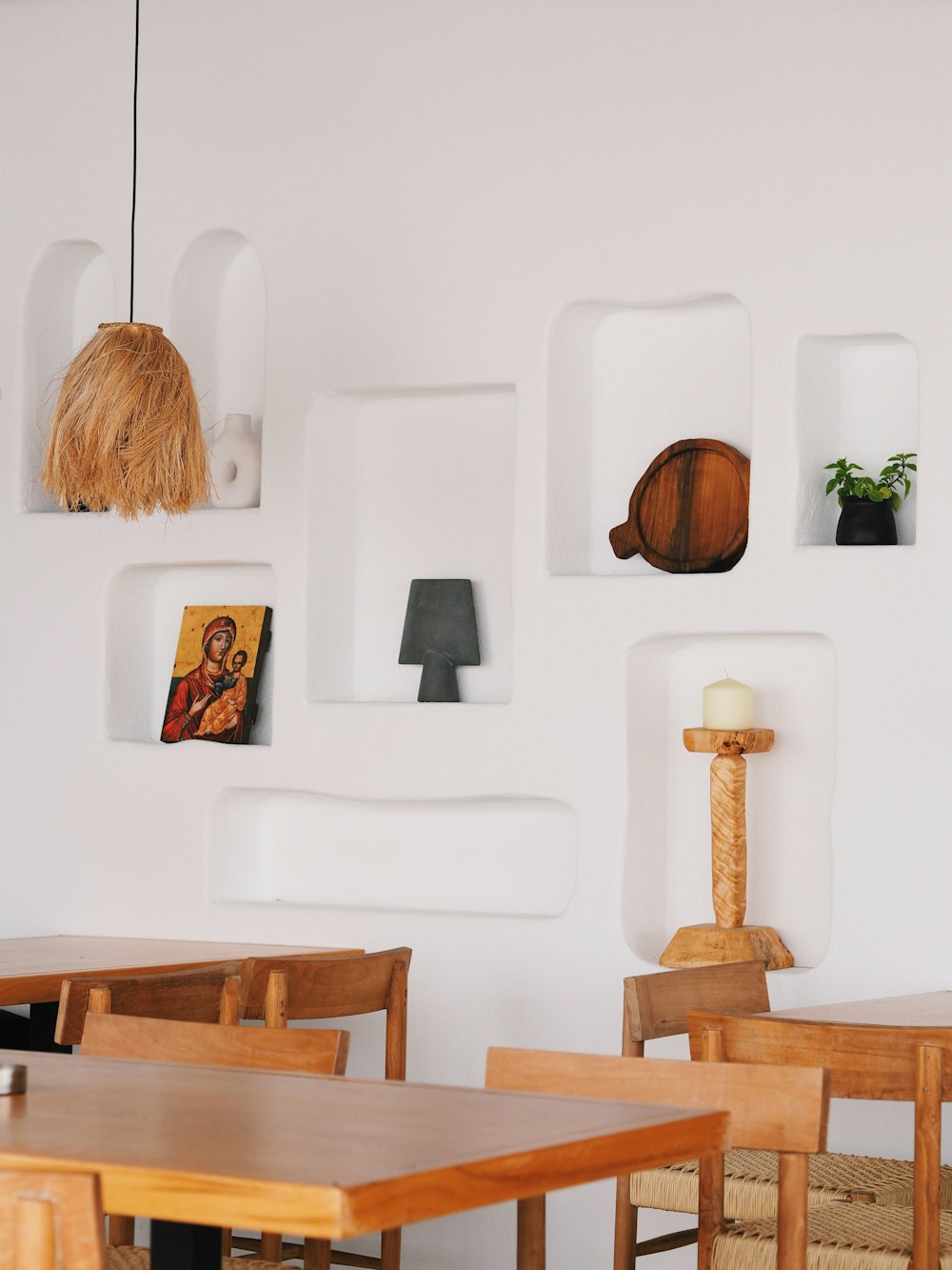 a white wall with a wooden table and chairs
