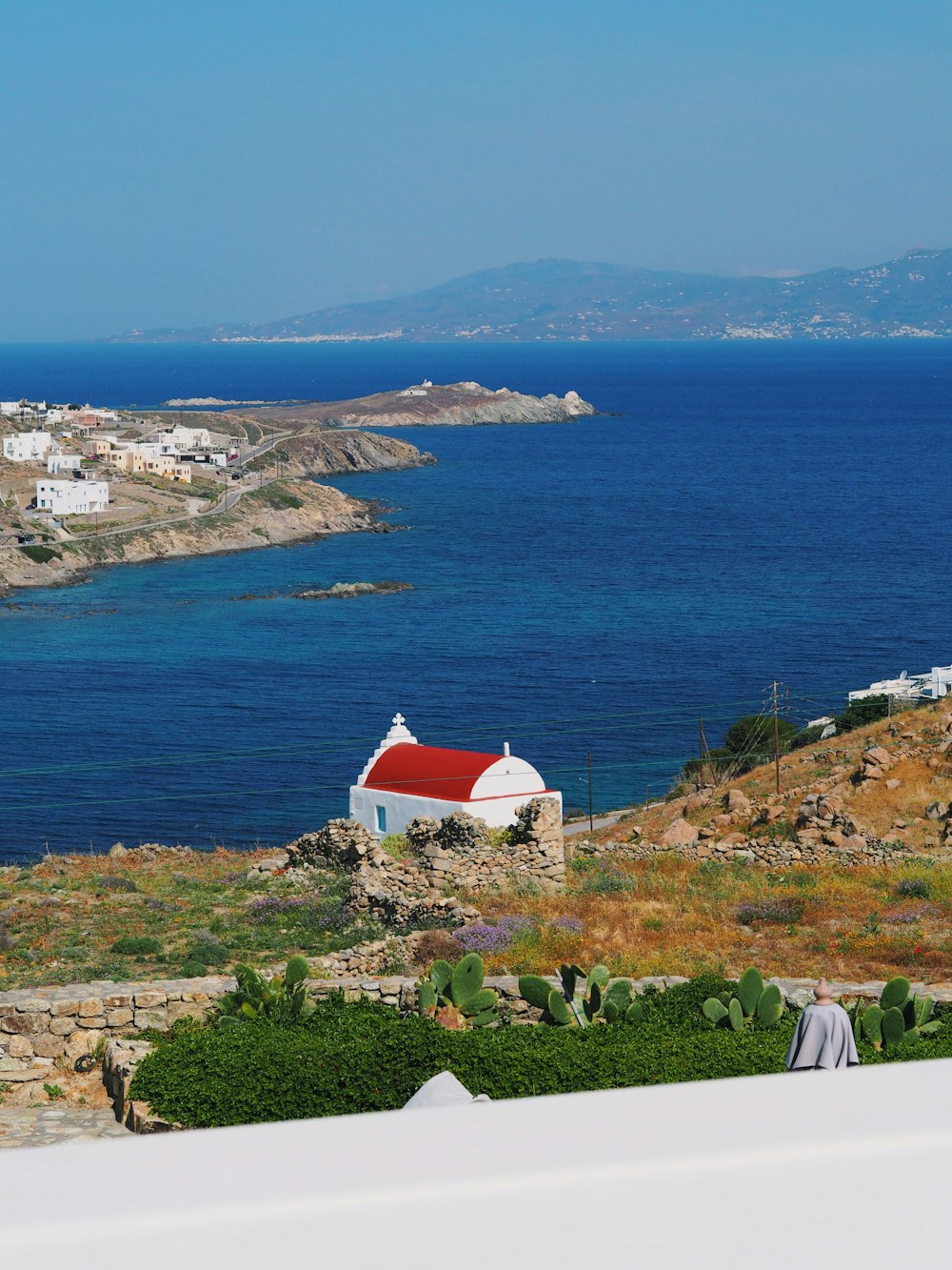 a white building with a red roof near the ocean