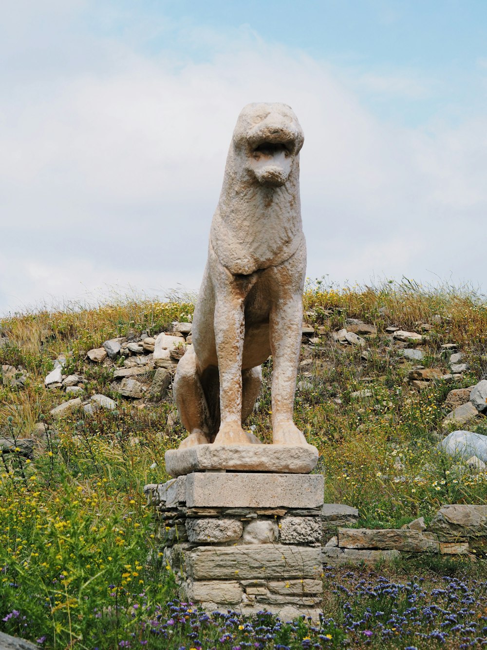 a statue of a dog sitting on top of a stone block