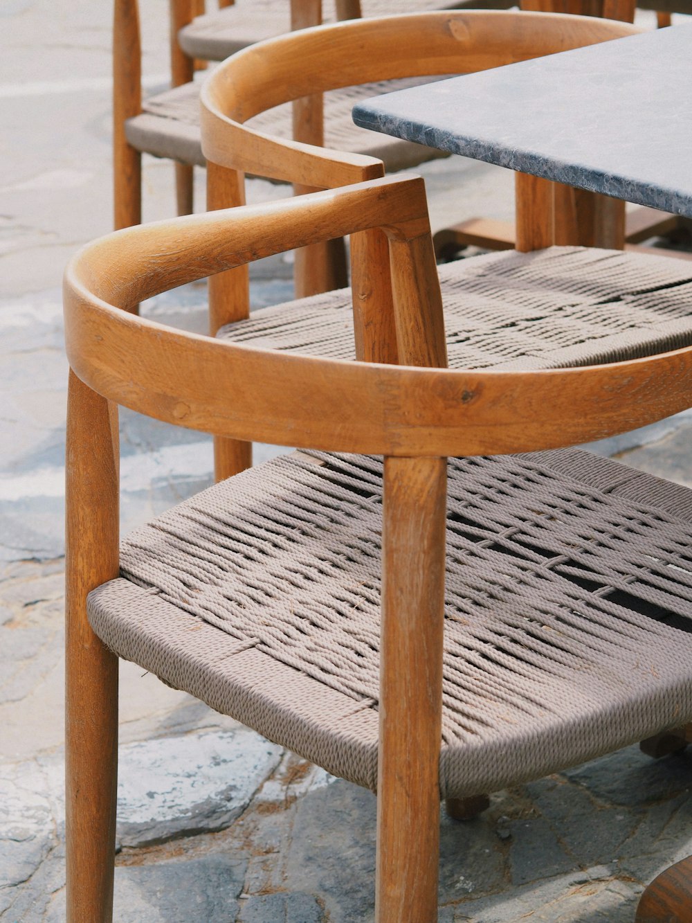 a row of wooden chairs sitting on top of a stone floor