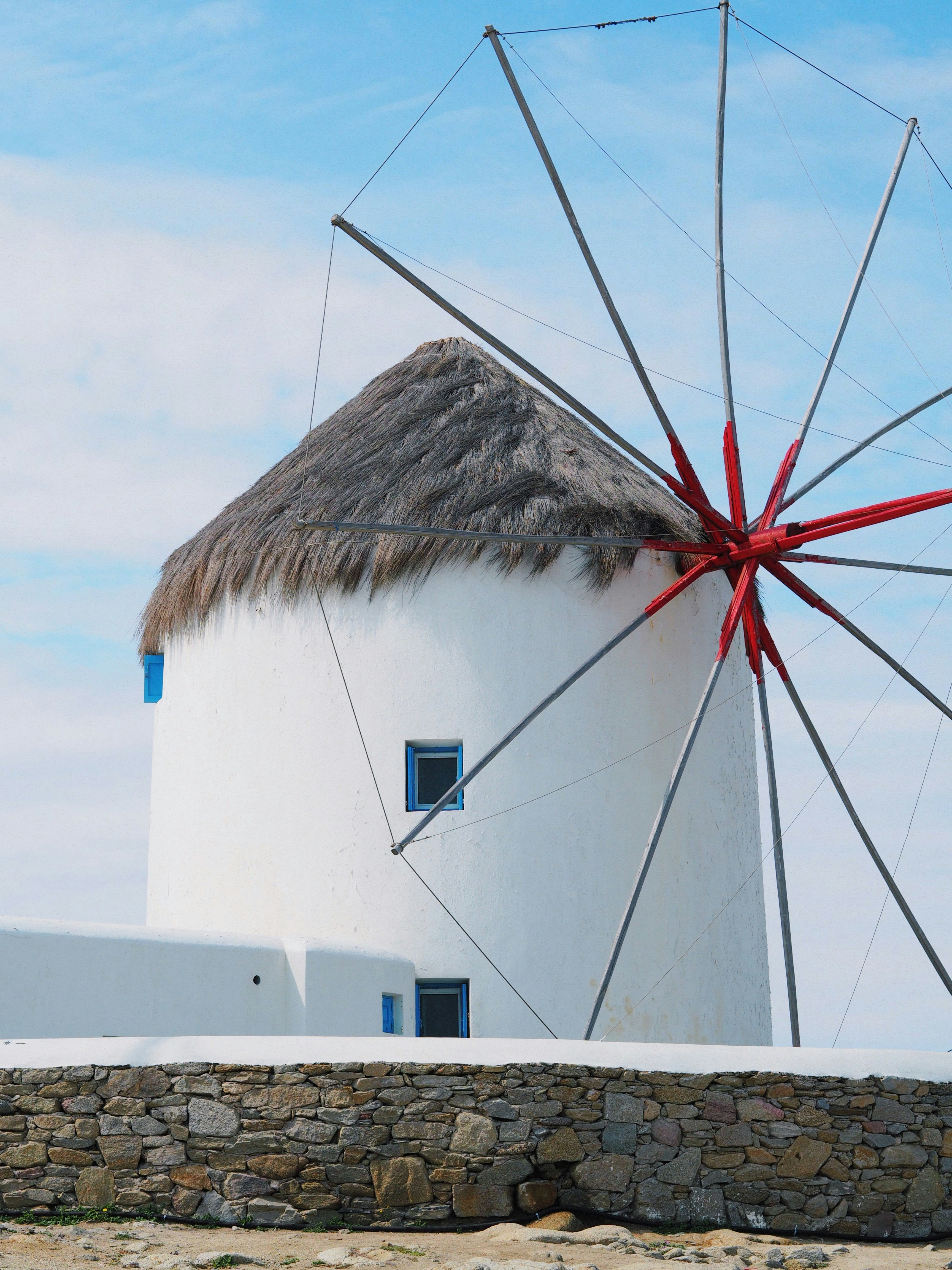 A white windmill with a red ribbon on it photo – Free Mykonos Image on ...