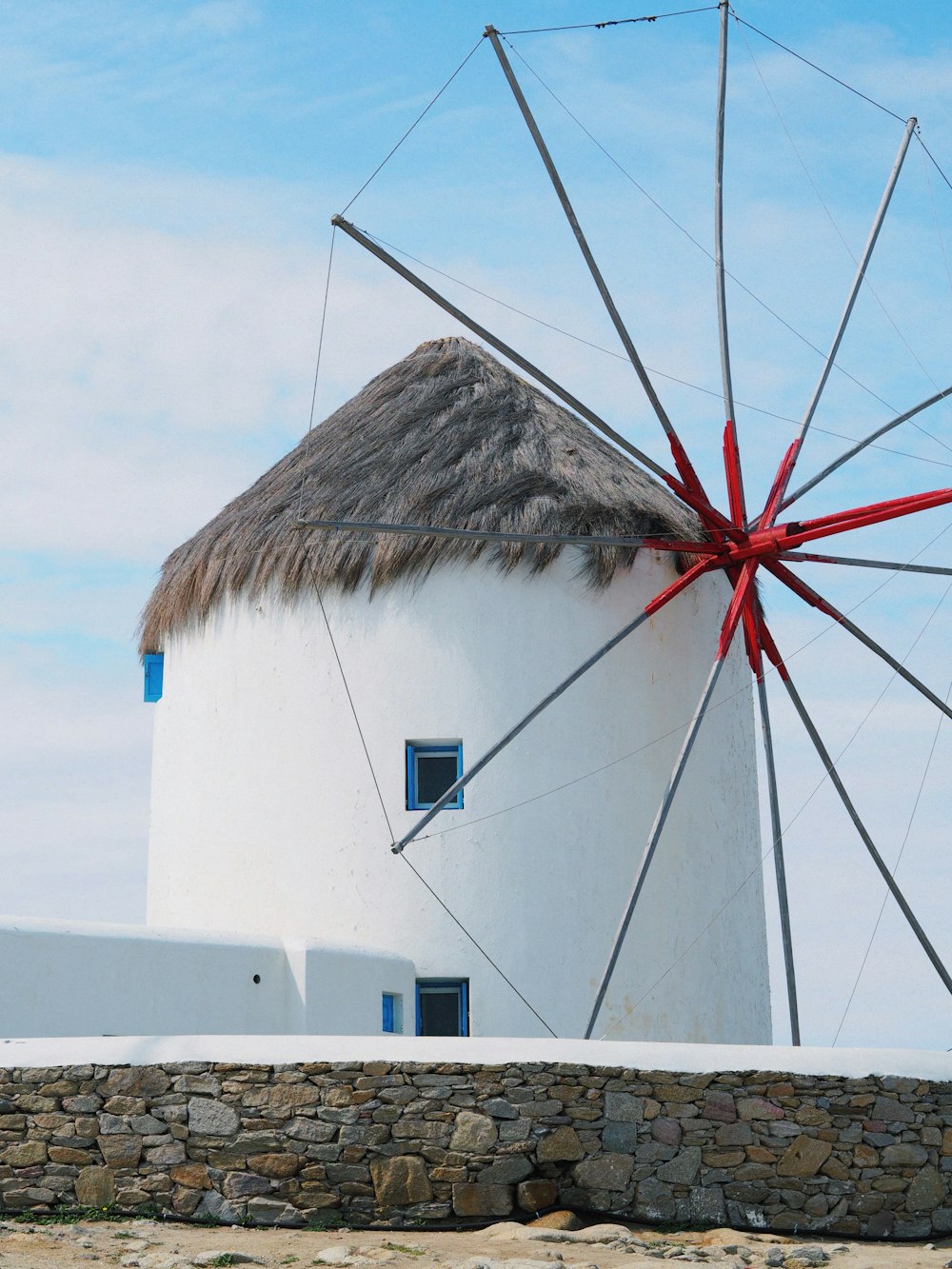 a white windmill with a red ribbon on it