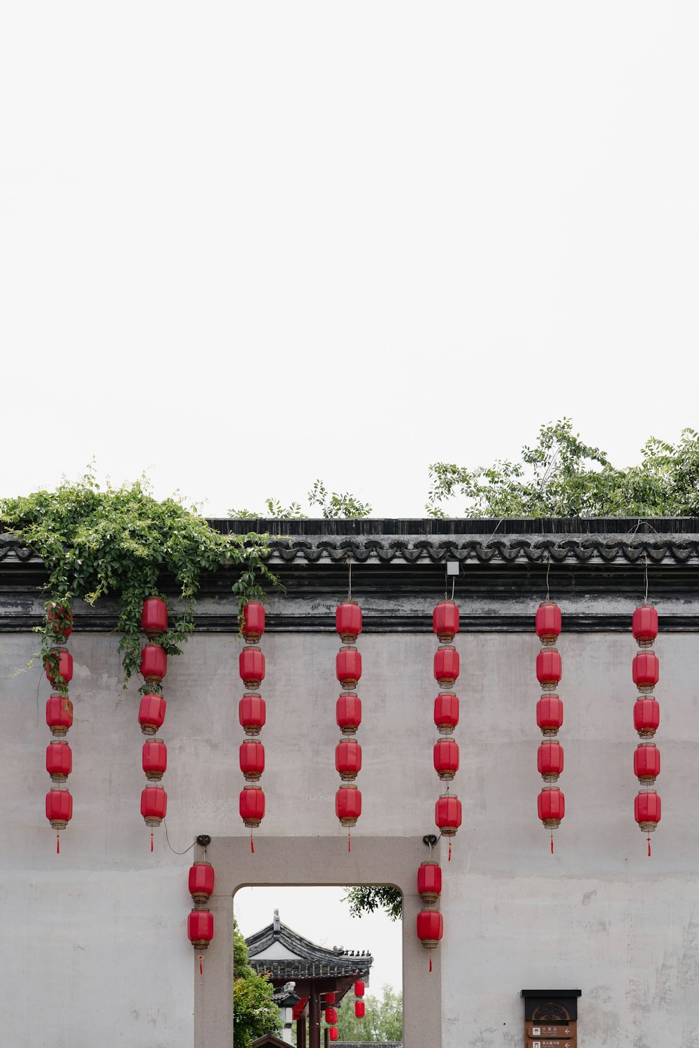 a white building with red lanterns hanging from it's side