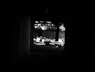 An abandoned cinema interior with torn velvet seats and dust particles floating in the dim light.