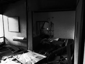 Broken plates scattered on the floor in a dimly lit room designed for safe smashing.
