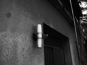 Electrician mounting outdoor lighting fixtures on a house exterior