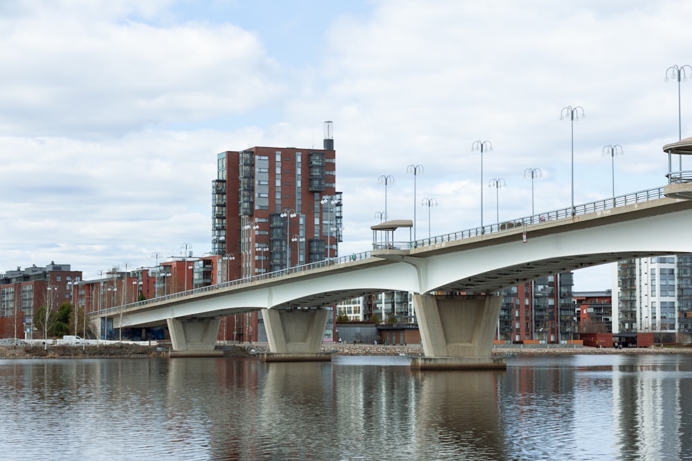 a bridge over a body of water with tall buildings in the background