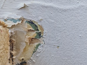 A close-up of surface preparation work being done on a wall.