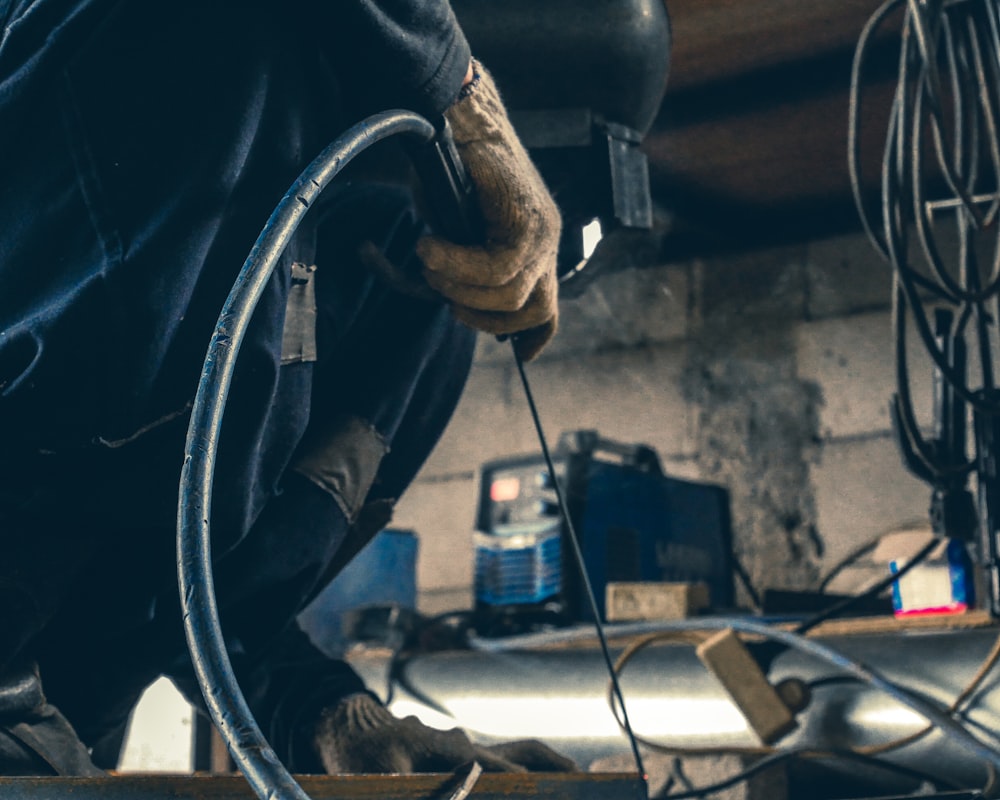 a man working on a piece of metal in a garage