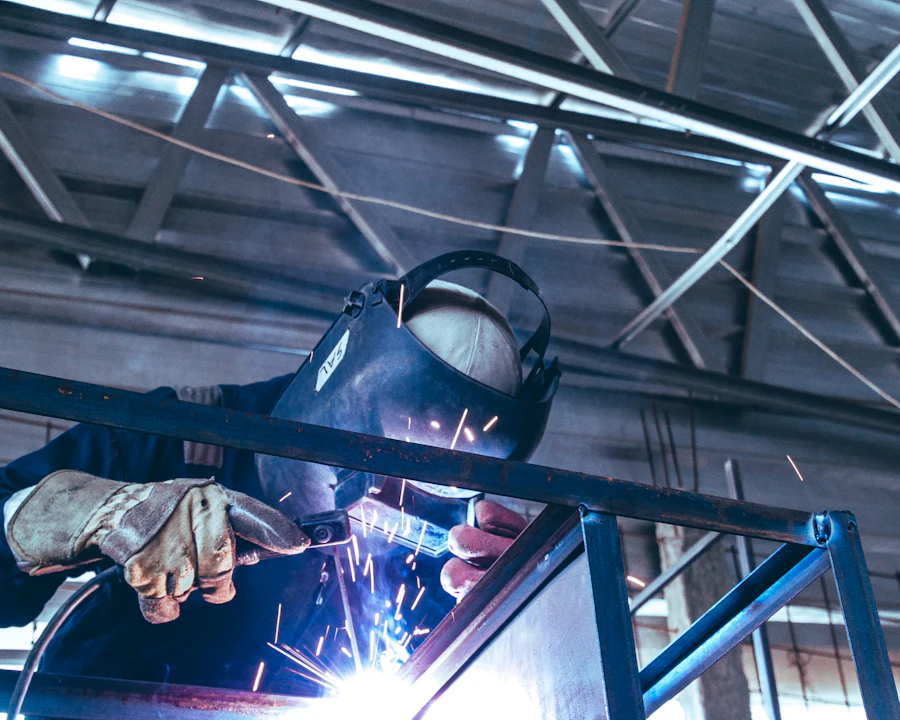 Machinist loading a part into a CNC milling machine in a training shop