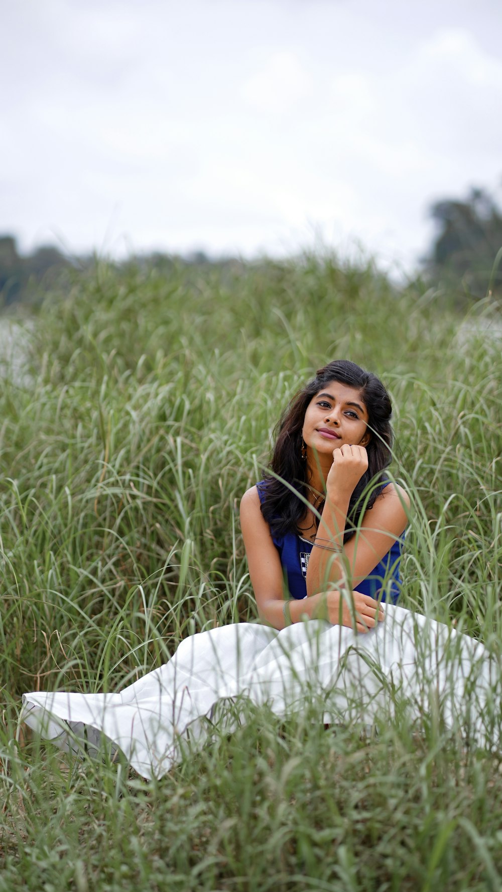 a woman sitting in a field of tall grass