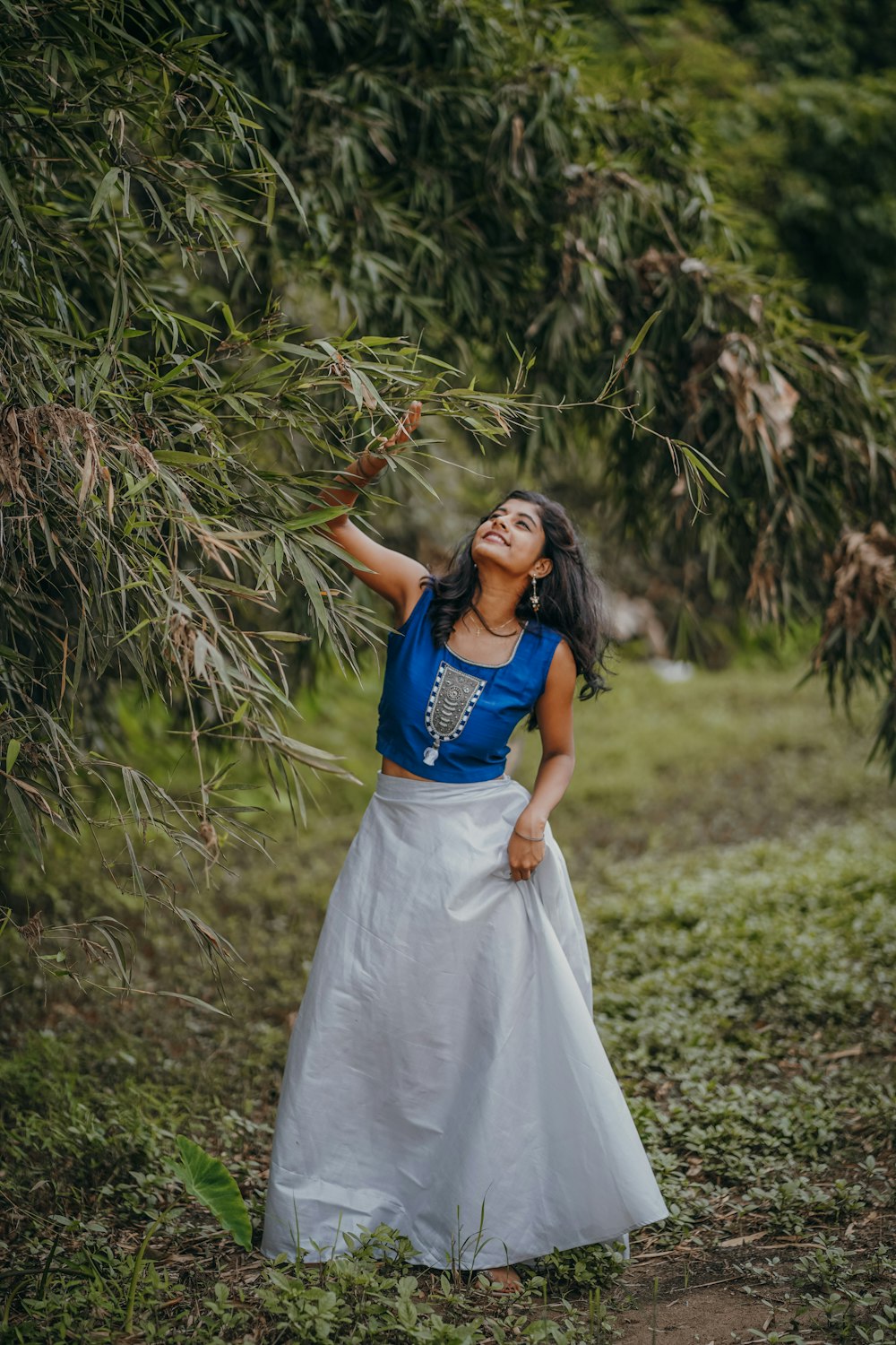 a woman in a white and blue dress standing in a field