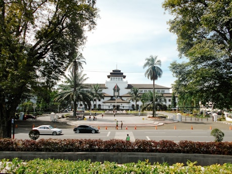 a large white building surrounded by trees and bushes