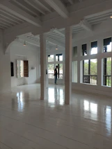 A friendly professional inspecting a freshly renovated apartment room with natural light.