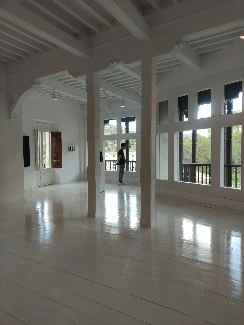 a person standing in a large room with white floors