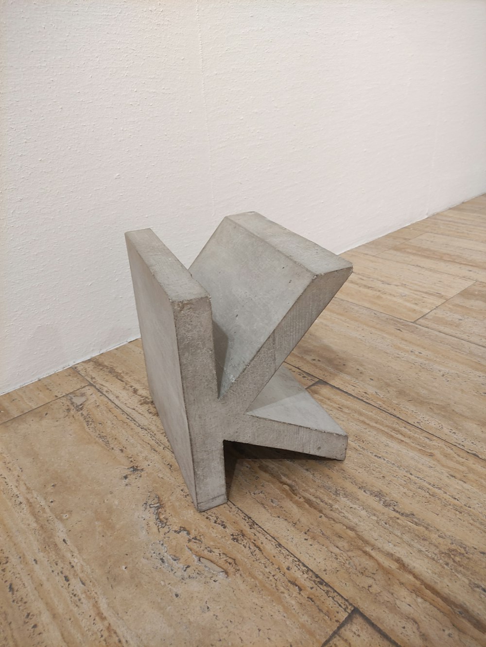 a concrete sculpture sitting on top of a wooden floor