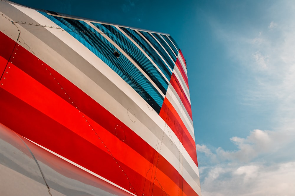 el costado de un avión con una franja roja, blanca y azul