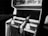 A black and white photograph of a vintage arcade shooting game machine with the title 'Clay Champ' visible on the top. Two rifle-like controllers are mounted in front of the machine. The surrounding area appears dimly lit, focusing attention on the arcade machine.