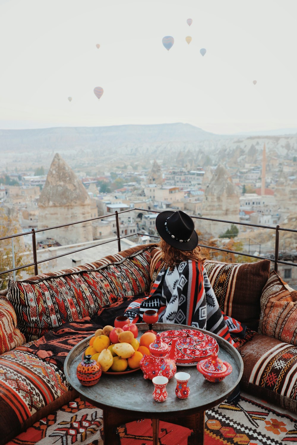 a woman sitting on a couch with a tray of fruit