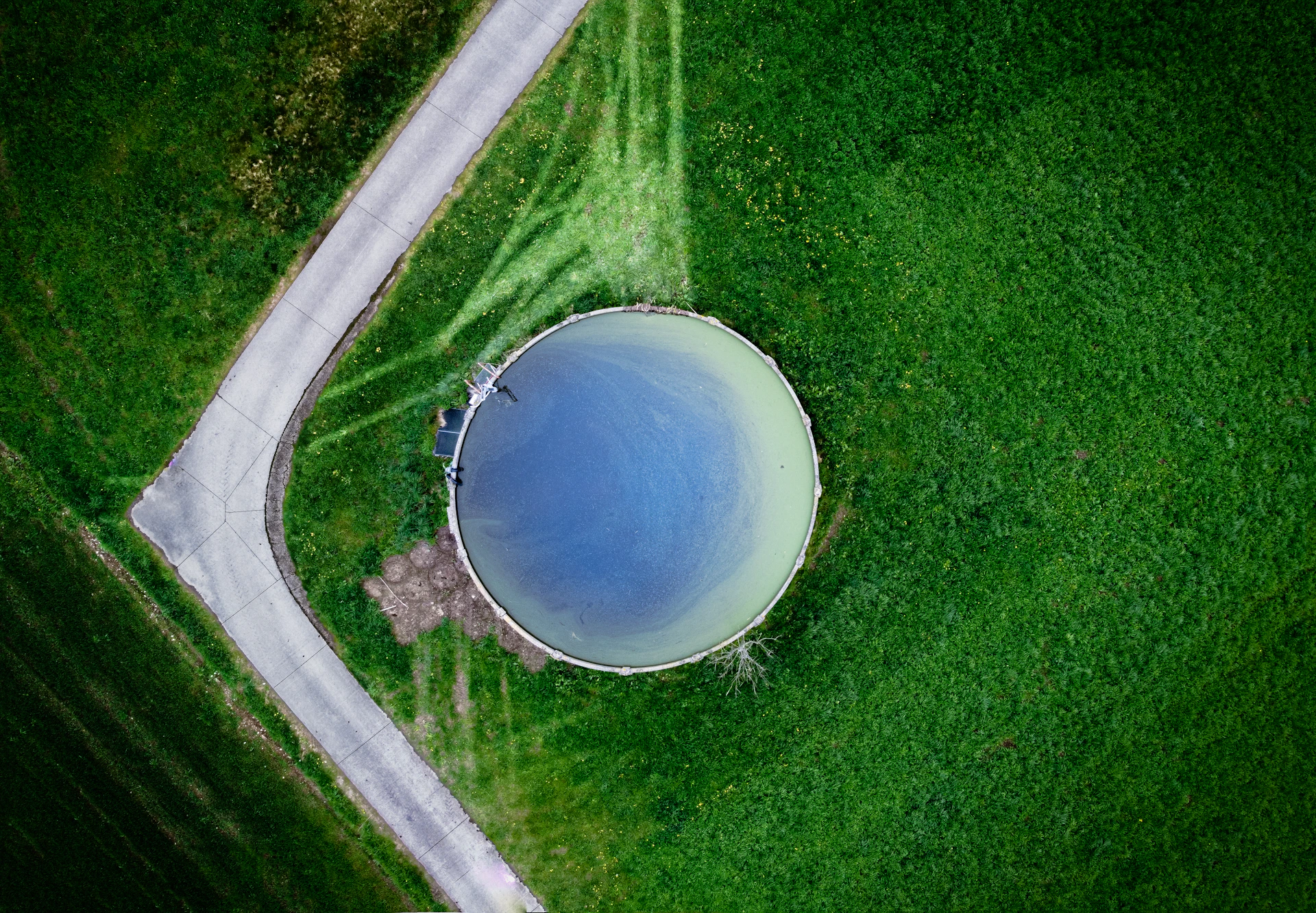 an aerial view of a body of water surrounded by green grass