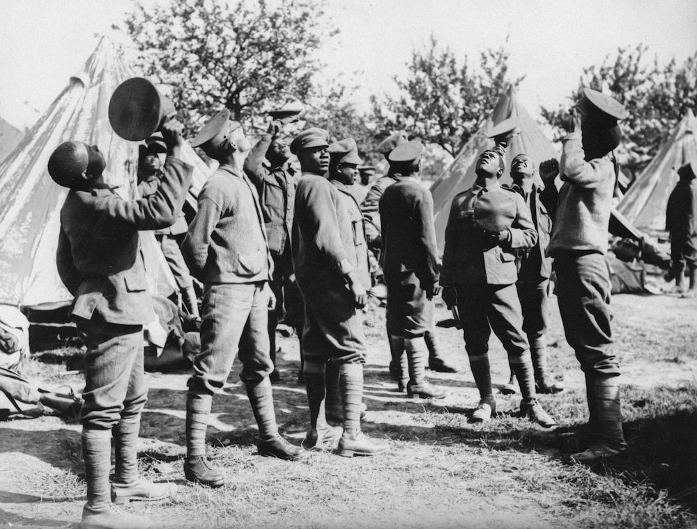 a group of men standing next to each other near a tent